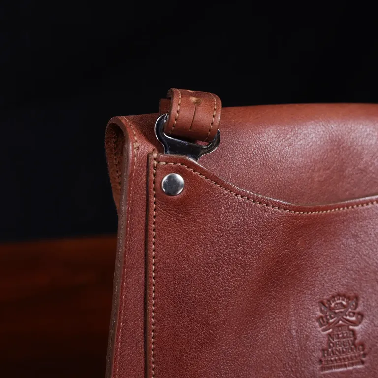 No. 22B Derby Handbag in Vintage Brown on a wood table with a dark background - detail view