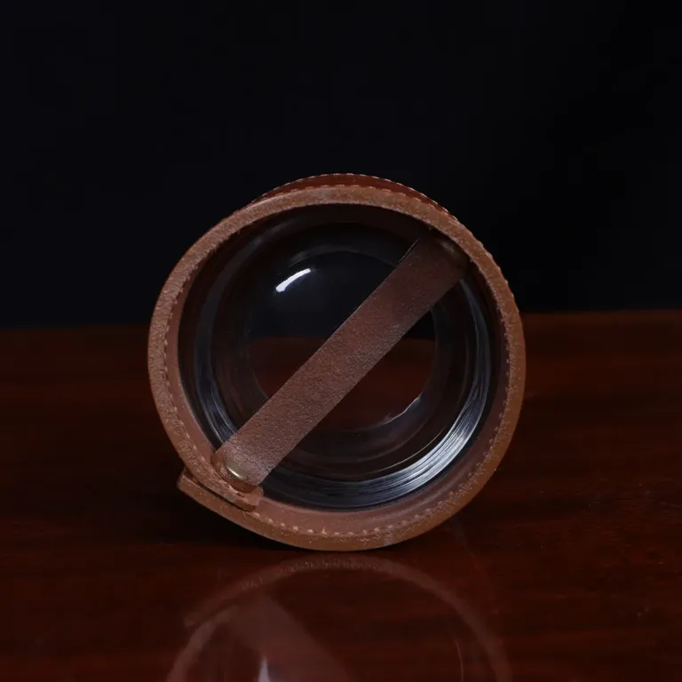 bottom view of leather veranda glass sleeve on wooden table with dark background