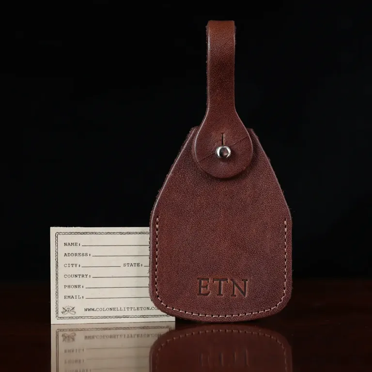 no14 leather vintage brown luggage tag with stamped personalization - on wood table and dark background