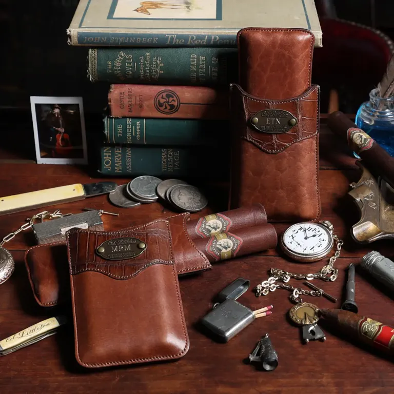 leather cigar case made in american buffalo with alligator trim with cigars, cigar cutter, watch, and books