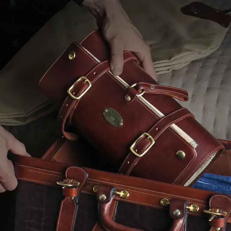 leather shave kit going into a travel bag
