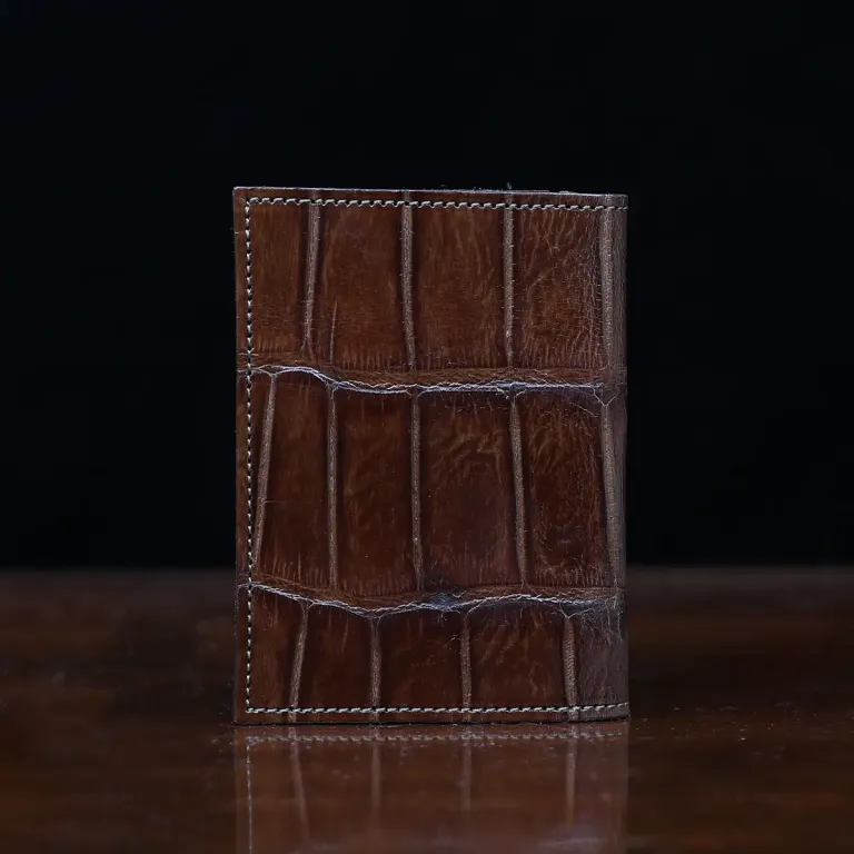 No. 2 card wallet in Vintage Brown American Alligator - ID 001 - back view on a wood table and dark background