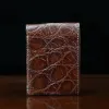 Front pocket wallet with flap in brown American Alligator - back view - 001 - on wood table with a dark background