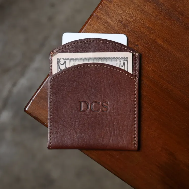 front side of the vintage brown front pocket wallet with cash and credit card on wood table