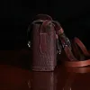 buffalo leather crossbody box bag on table - side view