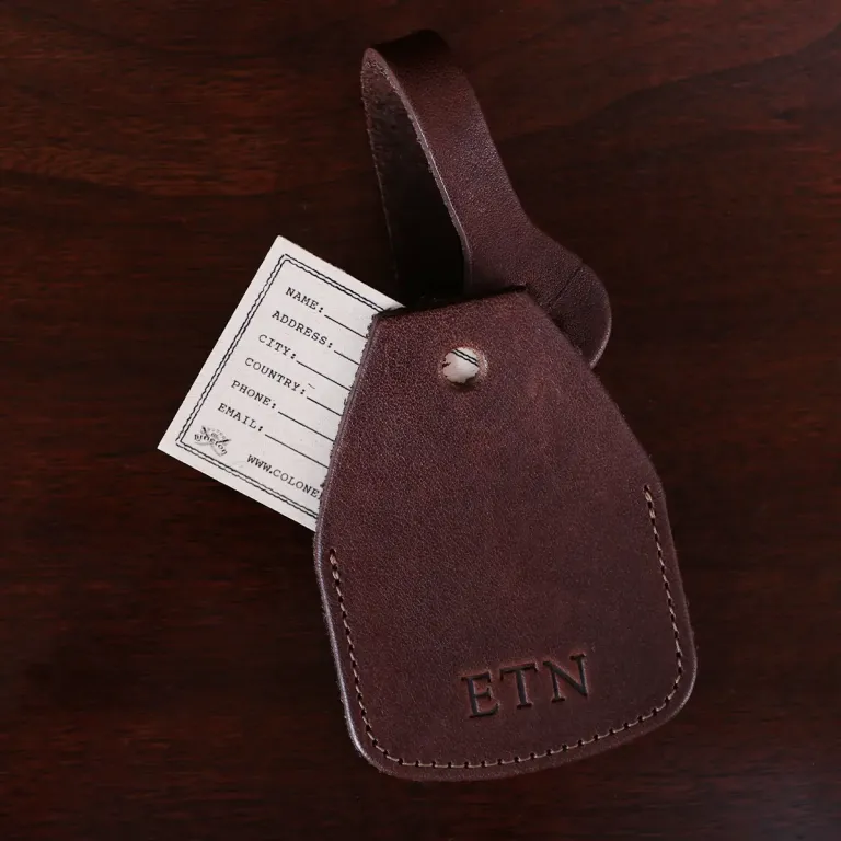 no14 leather vintage brown luggage tag with stamped personalization - open - on wood table and dark background