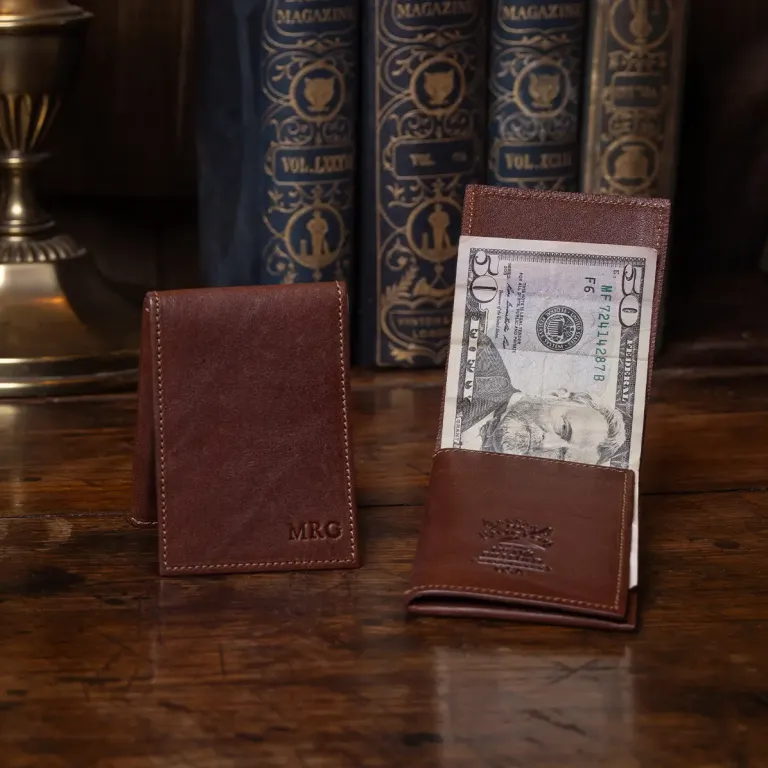 no 102 vintage brown billfold with personalization stamp - showing one open with cash and one closed with personalization on a wood table with books