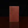 no 28 leather pocket journal on a wooden table with a dark background - fron view