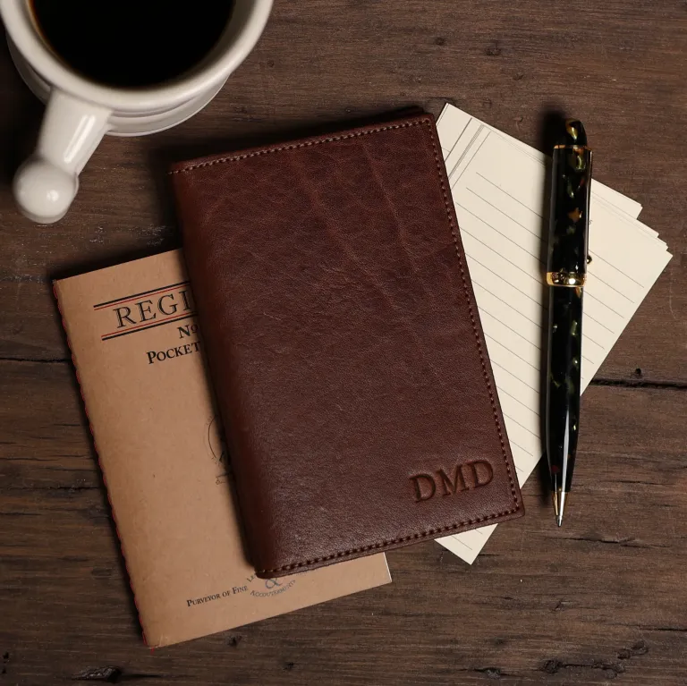 pocket journal sitting next to a cup of coffee, notecards and a pen