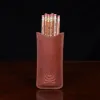 leather pencil case on wooden table with 12 pencils - back view
