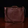no 16 brown vintage leather document bag with strap on a wooden table with a dark background - back view