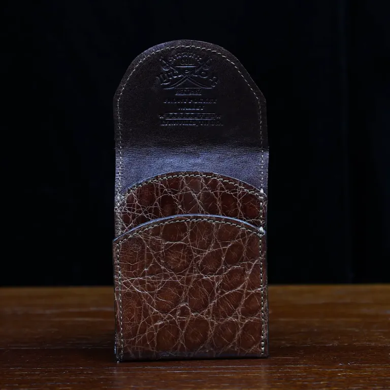 Front pocket wallet with flap in brown American Alligator - front view - 001 - on wood table with a dark background