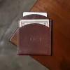 front side of the vintage brown front pocket wallet with cash and credit card on wood table