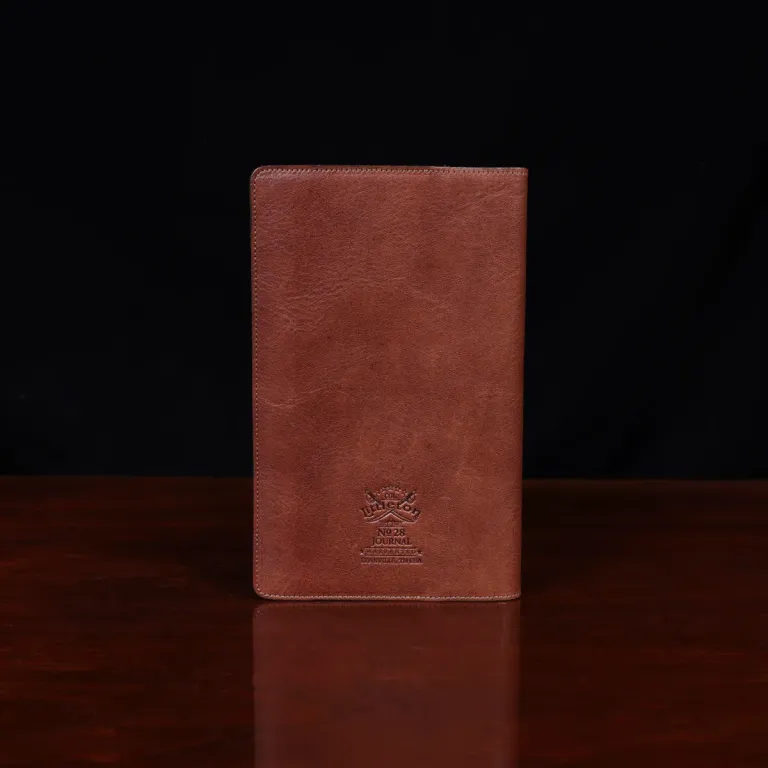no 28 leather pocket journal on a wooden table with a dark background - back view