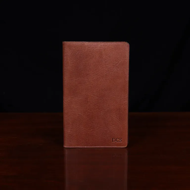 no 28 leather pocket journal on a wooden table with a dark background - fron view