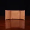 no 1 trifold wallet in brown steerhide on a wooden table with a dark background - front open empty view