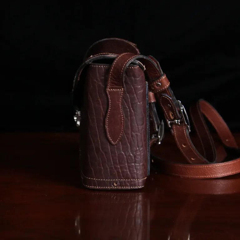 buffalo leather crossbody box bag on table - side view